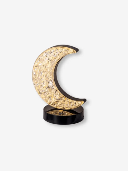 lampe de chevet en forme de croissant de lune cristal sur un socle noir