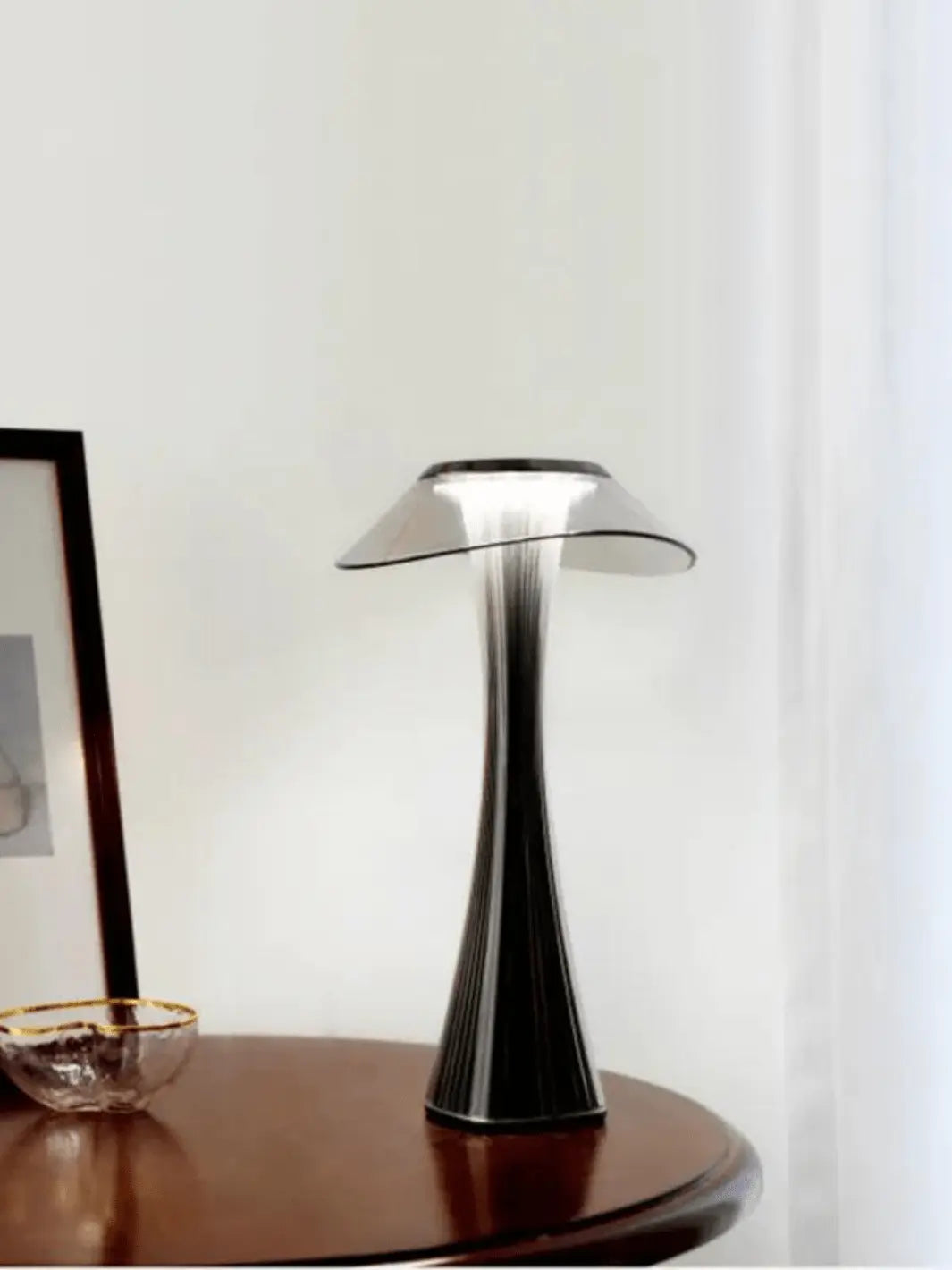 lampe de chevet sans fil moderne style champignon noire avec petit abat jour en verre posee sur une table en bois fonce