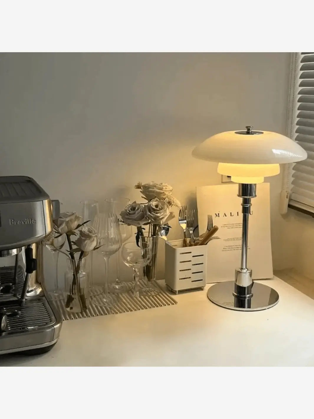 lampe de chevet en metal style champignon moderne et design posee sur un plan de travail a cote d une machine a cafe