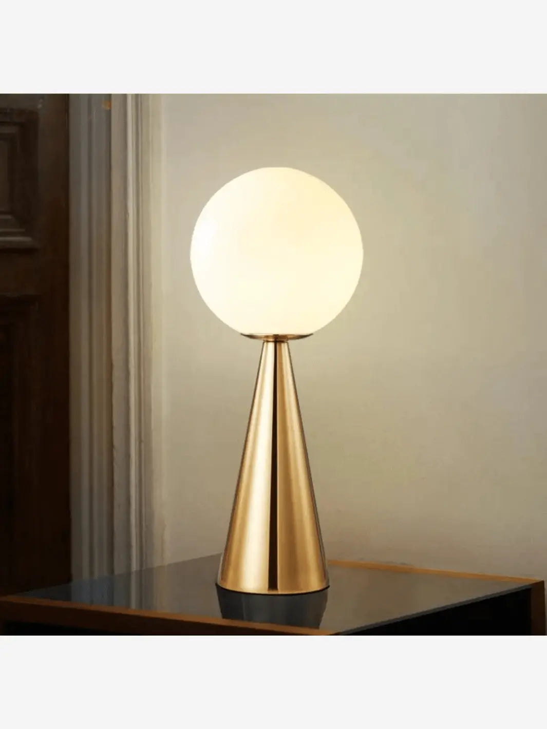 lampe de chevet representant un lampadaire moderne couleur doree posee sur une table de nuit