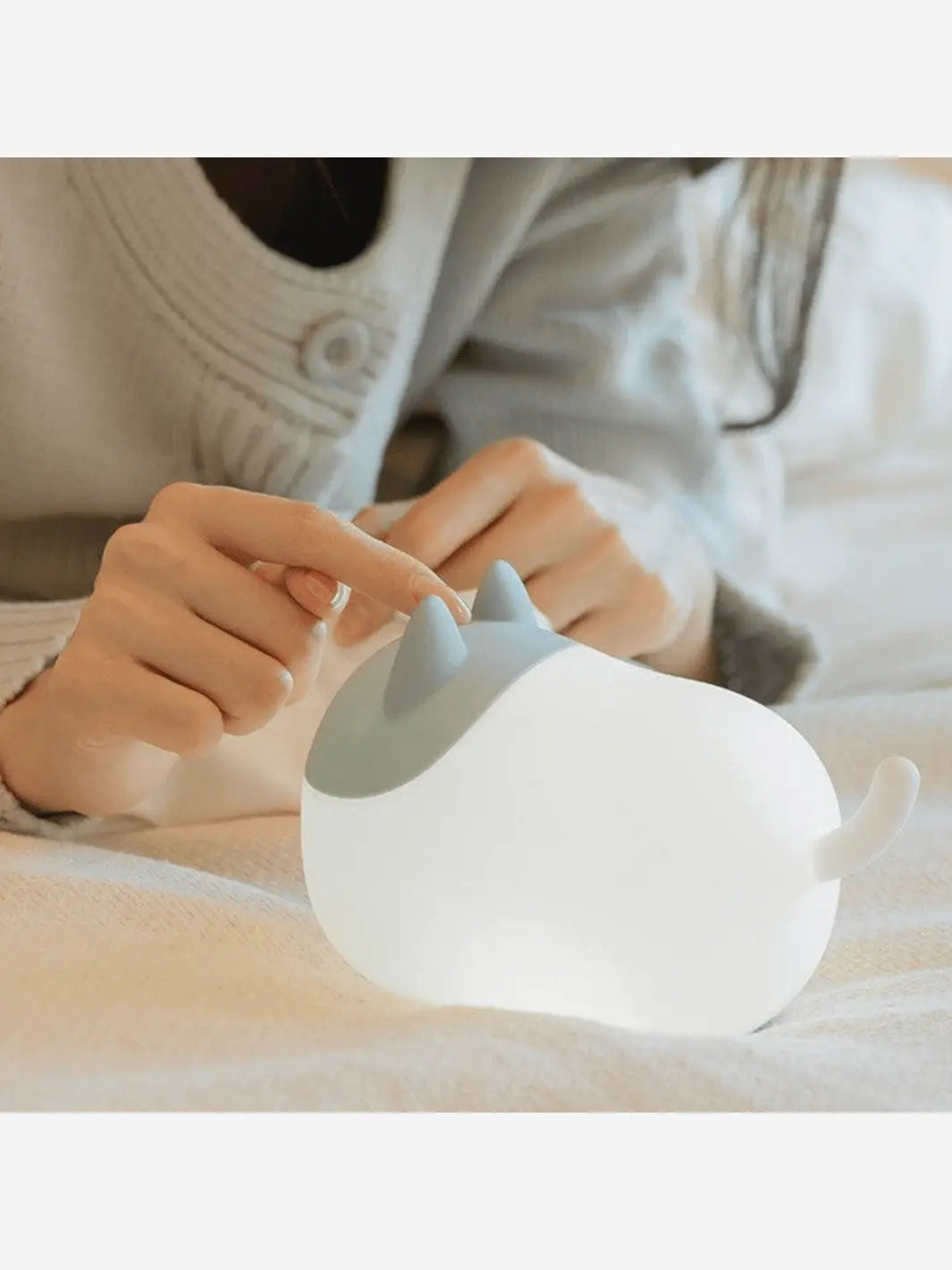 une femme utilise la lampe de chevet enfant sans fil en forme de chat luminoso